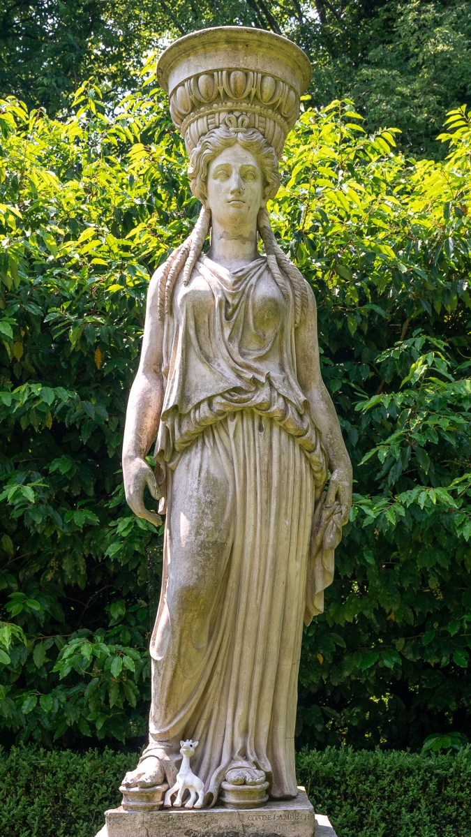 Classic caryatid with small toy giraffe at her feet