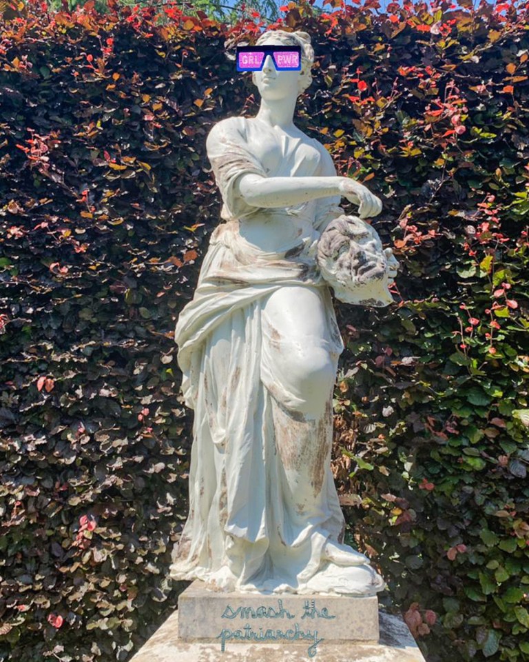 Statue of woman holding severed head of a man, with digitally added sunglasses saying GRL PWR