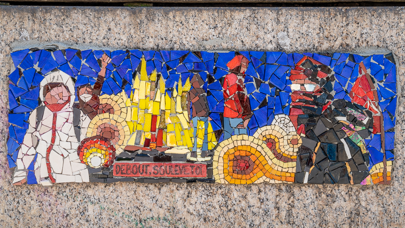 Mosaic of uprising, people in masks, fire and the words "Debout! Soulève-toi!