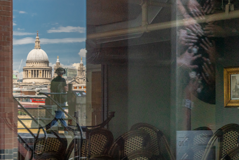 View of St Paul's Cathedral reflected in windows of an empty cafe