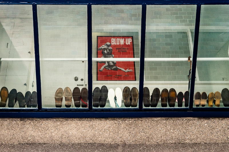 shoes stacked in a window and poster of Blow-up film