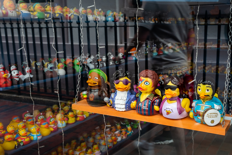 Toy ducks in shop window disguised as famous people