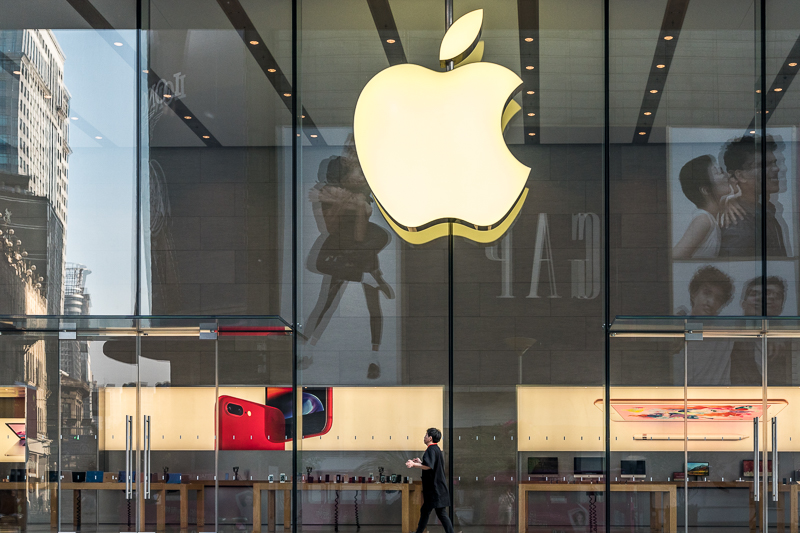 Someone walking past the Apple store in Shanghai