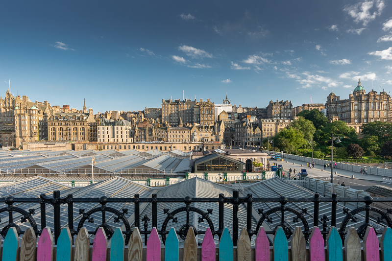 Edinburgh skyline with colourful wooden fence providing a jagged fringe at the bottom