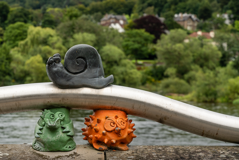 three miniature animal sculptures on edge of river