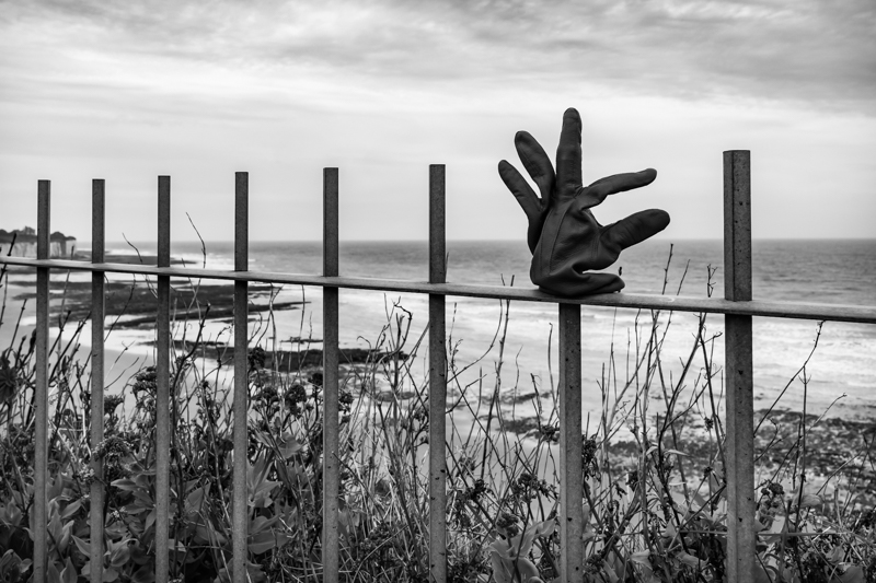 Lost glove on railings alongside beach
