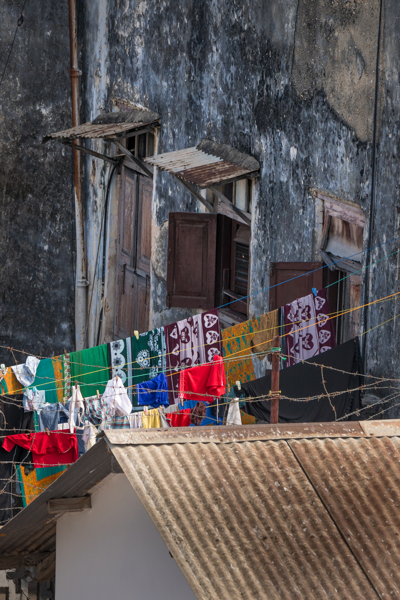 bright clothes on a washing line behind barbed wire in Stone Town