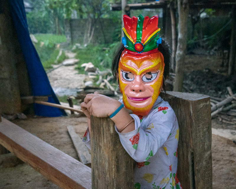 Young child in village wearing a mask